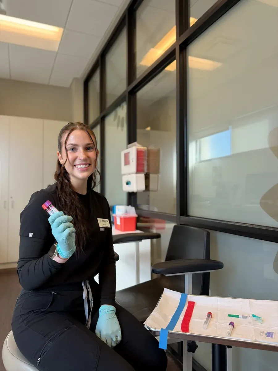 Averie in the lab draw room holding blood sample tubes