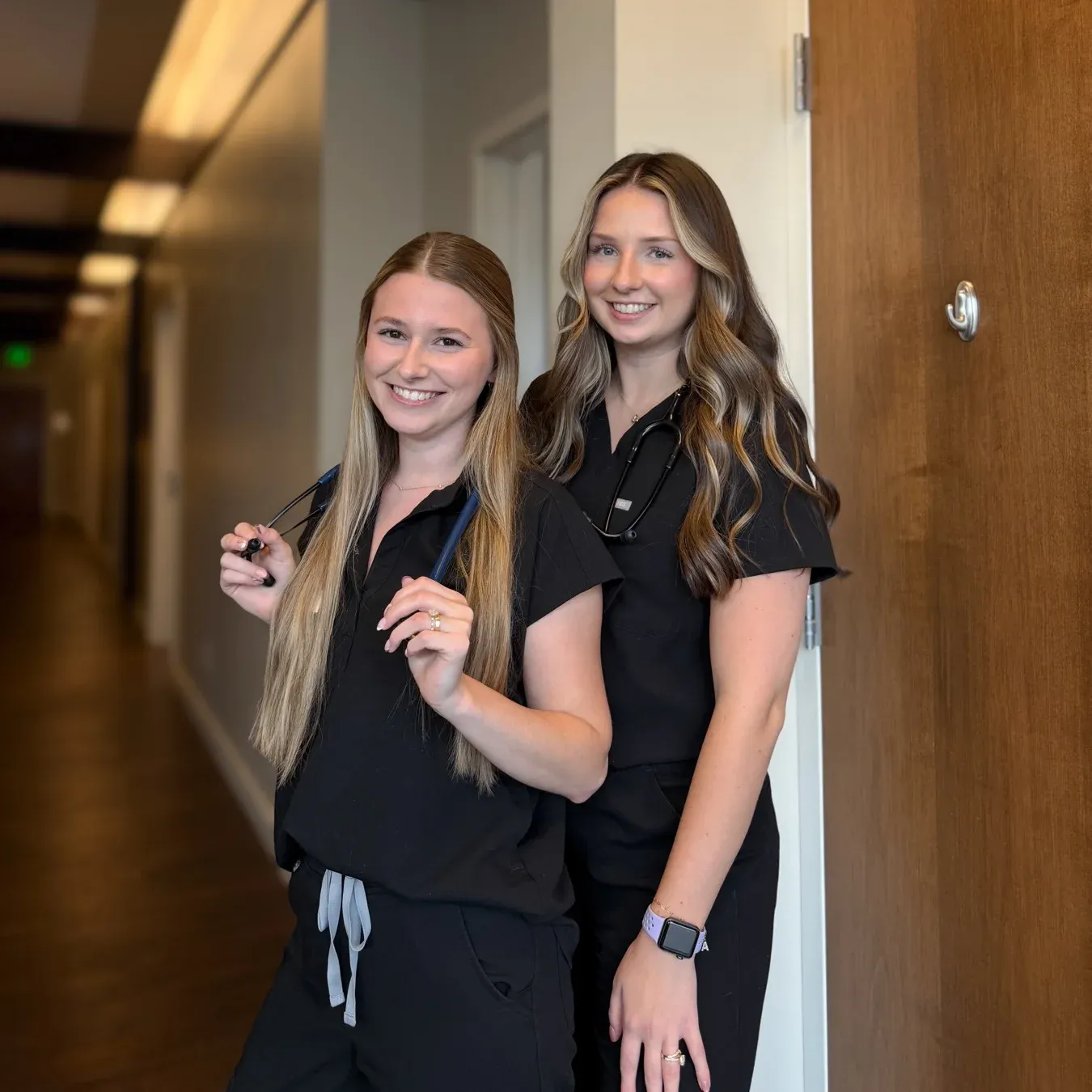 Two Prairie Health & Wellness nurses in the clinic hallway